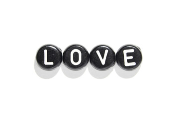Black and white love letter beads aligned on white background reflecting simple romance and...