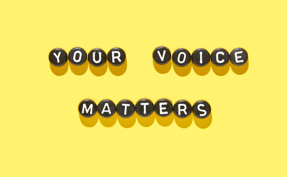 Inspiring quote your voice matters in black and white beads on vibrant yellow background for empowerment concept.
