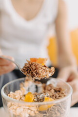 Happy asian woman eating healthy homemade snack made of yogurt.