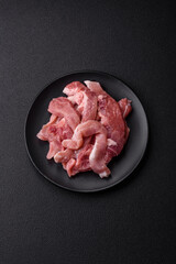 A pieces of raw fresh pork on a wooden cutting board with spices and herbs