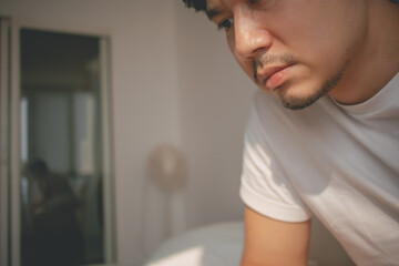 Close up depressed lonely asian man looking at mobile phone social media.