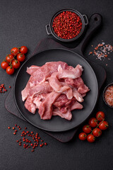A pieces of raw fresh pork on a wooden cutting board with spices and herbs