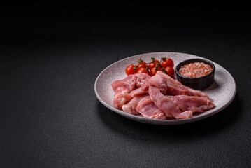 A pieces of raw fresh pork on a wooden cutting board with spices and herbs