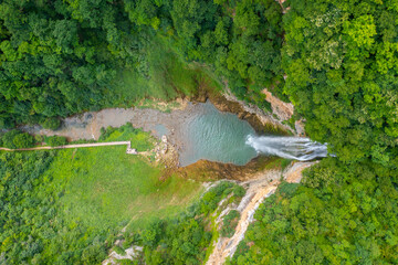 A beautiful waterfall with a wooden path to it surrounded by greenery - Bliha waterfall near Sanski Most in Bosnia and Herzegovina - top view