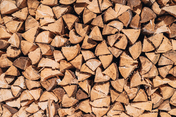 Stacked firewood in neat pile, natural background