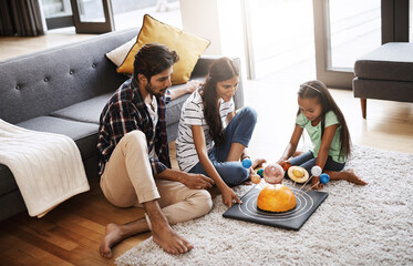 Parents, girl and smile for science homework with universe toys for education and knowledge. People, family and happy with helping kids in living room on floor for child growth and brain development
