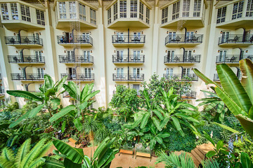 Lush Tropical Atrium with Balconies and Cascading Lights in Daytime View