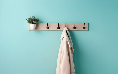 A pastel turquoise background with a stylish coat rack standing at the bottom right corner.