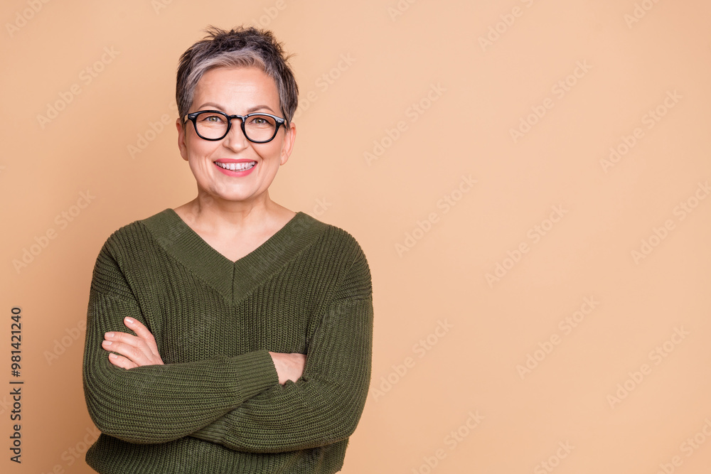 Canvas Prints Photo of cool woman with short hair dressed sweater in glasses hold arms crossed near empty space isolated on beige color background