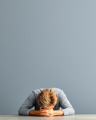 Stressed businessman hiding his face at desk with copy space