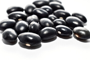 Black beans on white background. Close-up of beans.