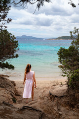 Woman in White Dress Strolling Toward Scenic Beach View