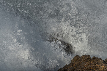 Large waves of the Atlantic Ocean crash against the rocks of a cliff