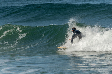 Surfer riding a wave on an Atlantic Ocean beach.