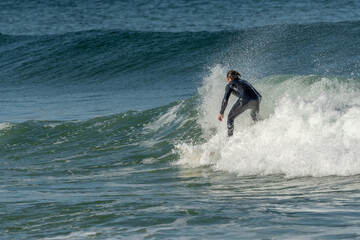 Surfer riding a wave on an Atlantic Ocean beach.