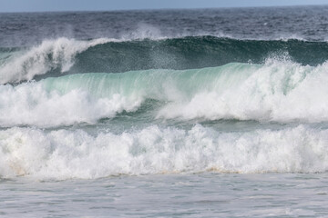 Wave of the green and blue Atlantic Ocean at the edge of a beach in the Iroise Sea.