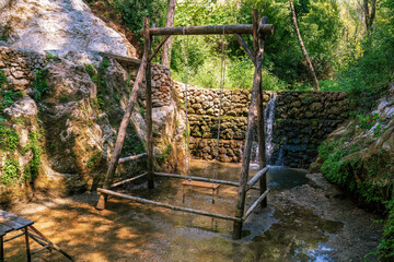 Rustic Wooden Swing Near Tranquil Waterfall in Forest