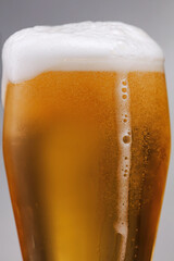 Close up of overflowing Beer. Glass of fresh and cold craft beer. Glass of fresh and cold beer with bubbles. Shallow depth of field