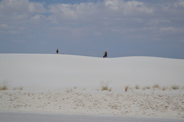 People are walking on the sand dunes of White Sands, New Mexico