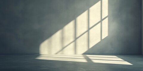 Obraz premium Sunlight streams through a window, creating striking shadows on the bare concrete floor of an unoccupied room
