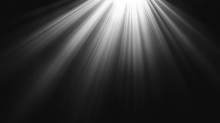 Obraz premium A spotlight shines brightly from the top of the frame, casting a dramatic beam of light across a dark, black background.