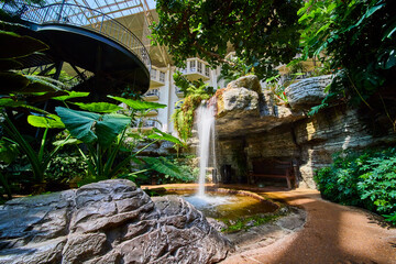 Indoor Waterfall Oasis with Tropical Foliage and Spiral Staircase Low Angle