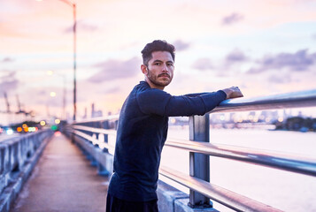 Fototapeta premium Man, portrait and sunrise on city bridge with sport, athlete and fitness break for training in the morning. Exercise, urban and confidence by the road ready for run and marathon at dawn in New York