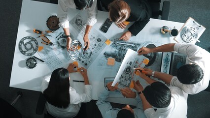 Top down aerial view of smart engineer team working together to design turbine engine. Professional...