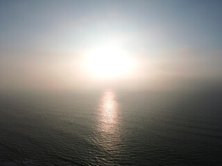 The Serene Ocean Sunrise wrapped in a Soft Fog Creates a Beautiful Atmosphere to Enjoy