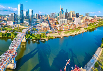 Fototapeta premium Aerial Panorama of Nashville Skyline and Cumberland River with Pedestrian Bridge