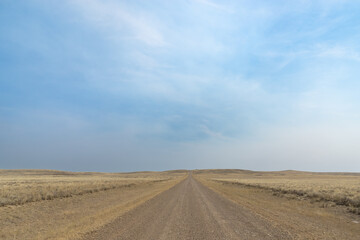 Long secluded rural dirt country road in the middle of nowhere for road trip to off road adventure to solitude and escape to unplug