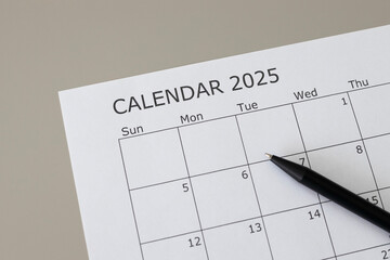 2025 calendar close up. Blank calendar with 2025 writing and a pen .