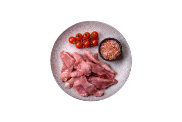 A pieces of raw fresh pork on a wooden cutting board with spices and herbs
