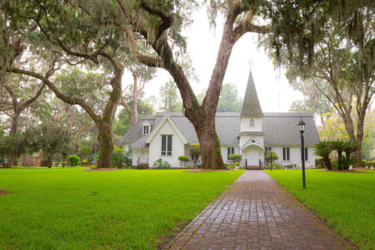 Grassy yard leading to white episcopal church building
