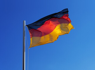 German national flag in strong wind against blue sky