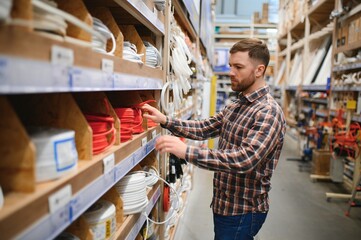 Worker selects an electrical cable at a hardware store
