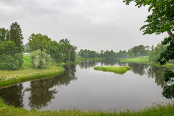 Fototapeta premium Gentle ripples dance across the water as trees frame the tranquil river, creating a peaceful oasis enhanced by the soft glow of twilight.