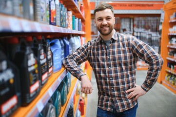 seller man with canister of motor oil in auto store