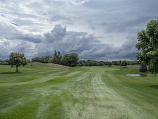 rain clouds over a green fairway on a golf course 