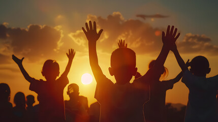 Fototapeta premium Silhouette of a refugee child group playing at sunset, with raised hands in worship, representing hope, freedom, faith, and praise