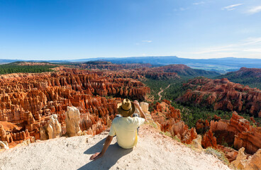 Happy man with a  yellow shirt on trail in beautiful nature landscape with hoodoos, pinnacles and...