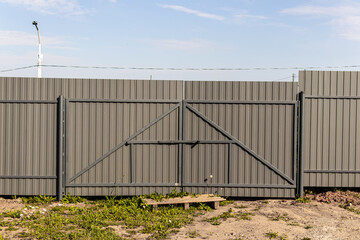 Fototapeta premium Grey metal profile sheet fence. Car fence gate