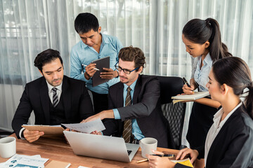 Diverse of business people from various ethnic group working in modern office environment. Productive and multi ethnic office workers engage in discussion for strategic business marketing. Meticulous