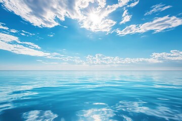 Obraz premium Calm ocean waters reflect the clear blue sky and radiant sun during a tranquil midday in a serene coastal area