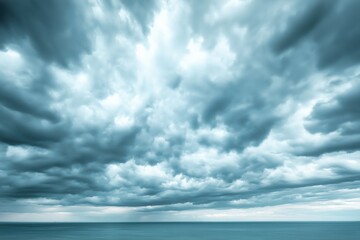 Dramatic storm clouds overhead at the coast, signaling an approaching storm on a tranquil ocean