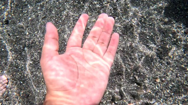 mano dentro de manantial de agua clara