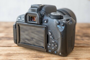 Modern dslr camera sitting on wooden table back side showing