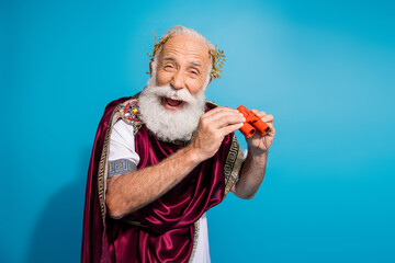 Photo of joyful funny man hold binoculars enjoy performance antique hero isolated on blue color...