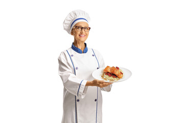 Female chef holding a cooked salmon with rice on a plate, fine dining concept