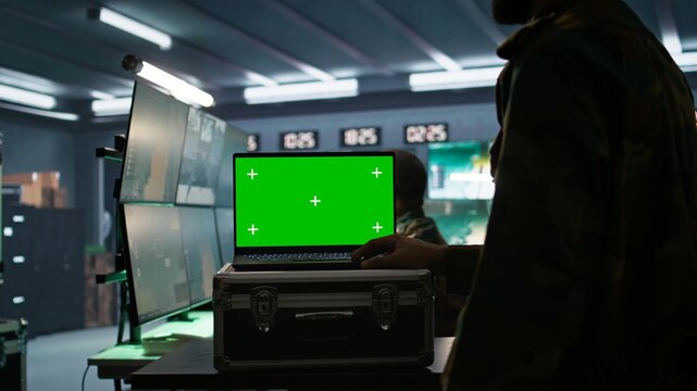 Army telecommunication systems operator using green screen gear, providing combat support. Military dispatcher managing communications networks with mockup laptop, camera B